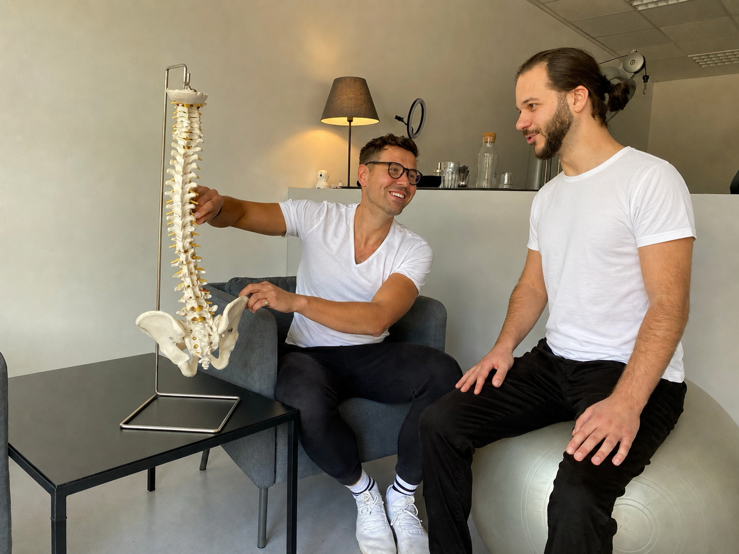Zwei Physiotherapeuten besprechen anhand eines Wirbelsäulenmodells eine Behandlungsstrategie
